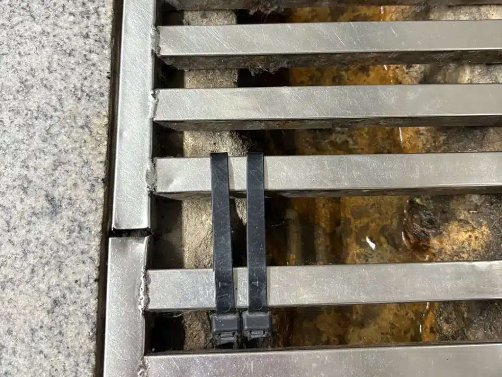 Cable ties used to fix sectional drain covers in subway station