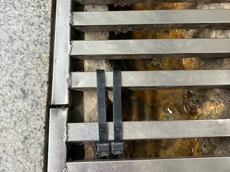 Cable ties used to fix sectional drain covers in subway station