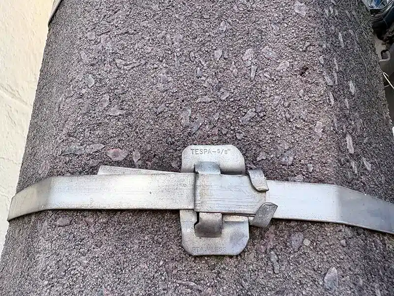 Stainless steel cable tie with Ear-Lokt buckle clamped around a street pole