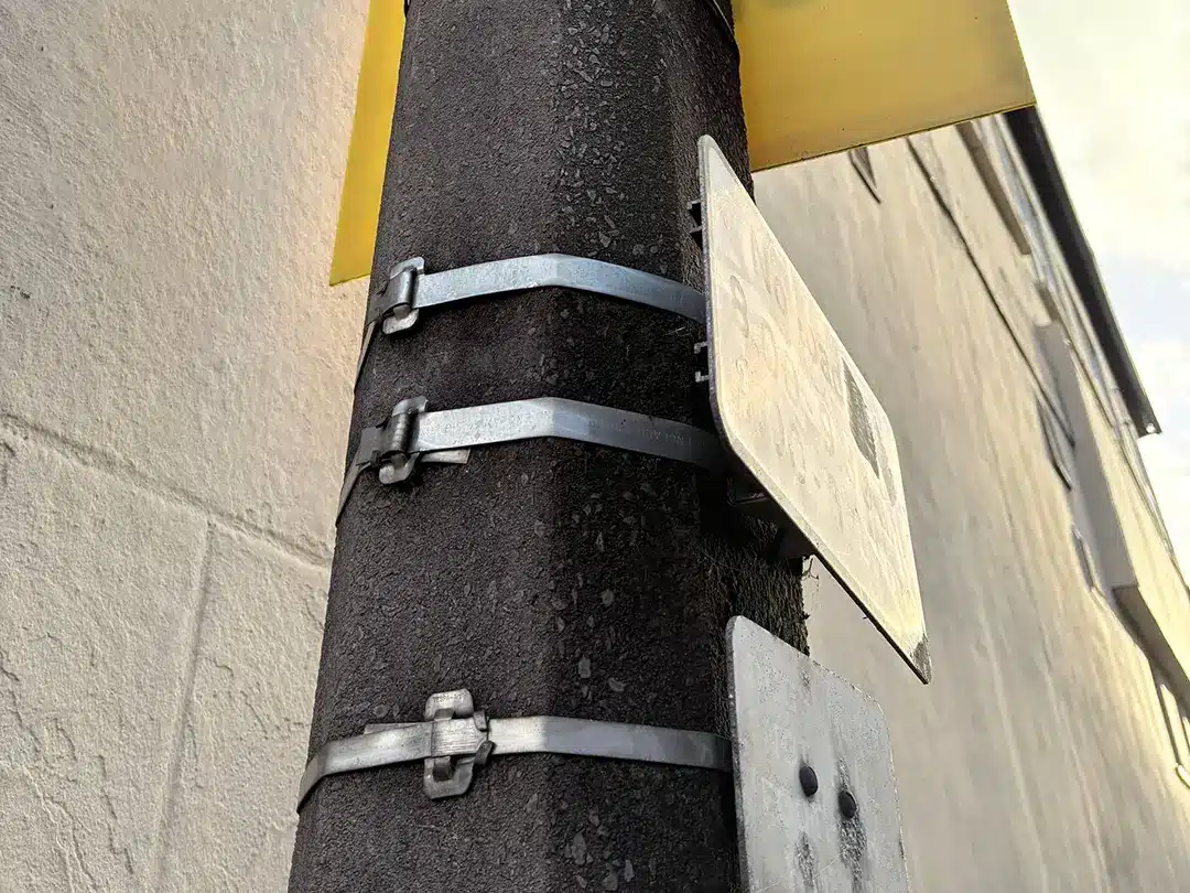 Stainless steel cable ties with Ear-Lokt buckles securing a road sign to a street pole in the UK