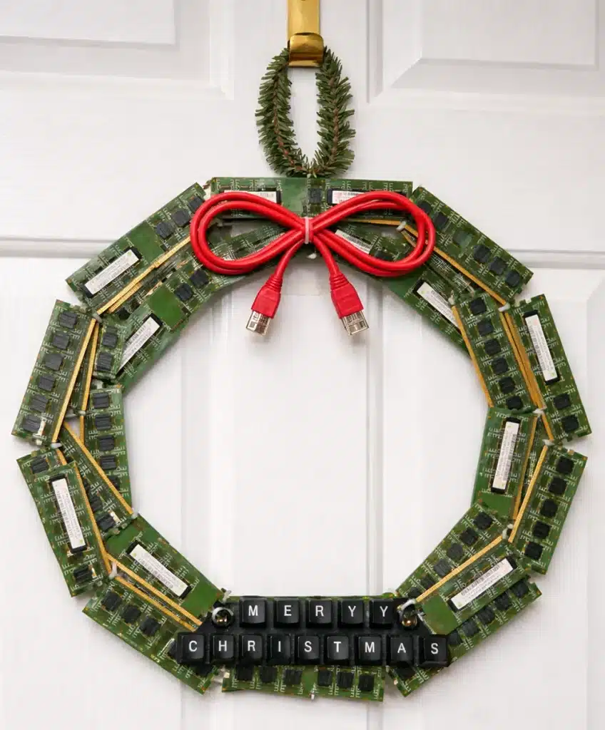Cable ties securing old RAM sticks into a DIY Christmas wreath, with a red USB cable bow and keyboard-key message