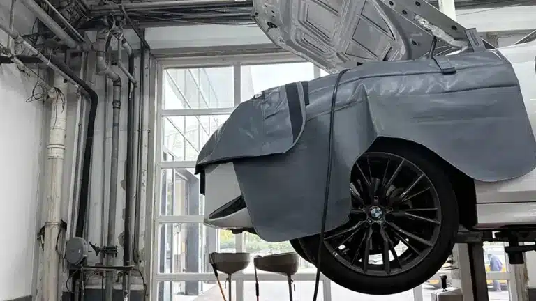 Cable ties in a BMW workshop service bay with a car on a lift