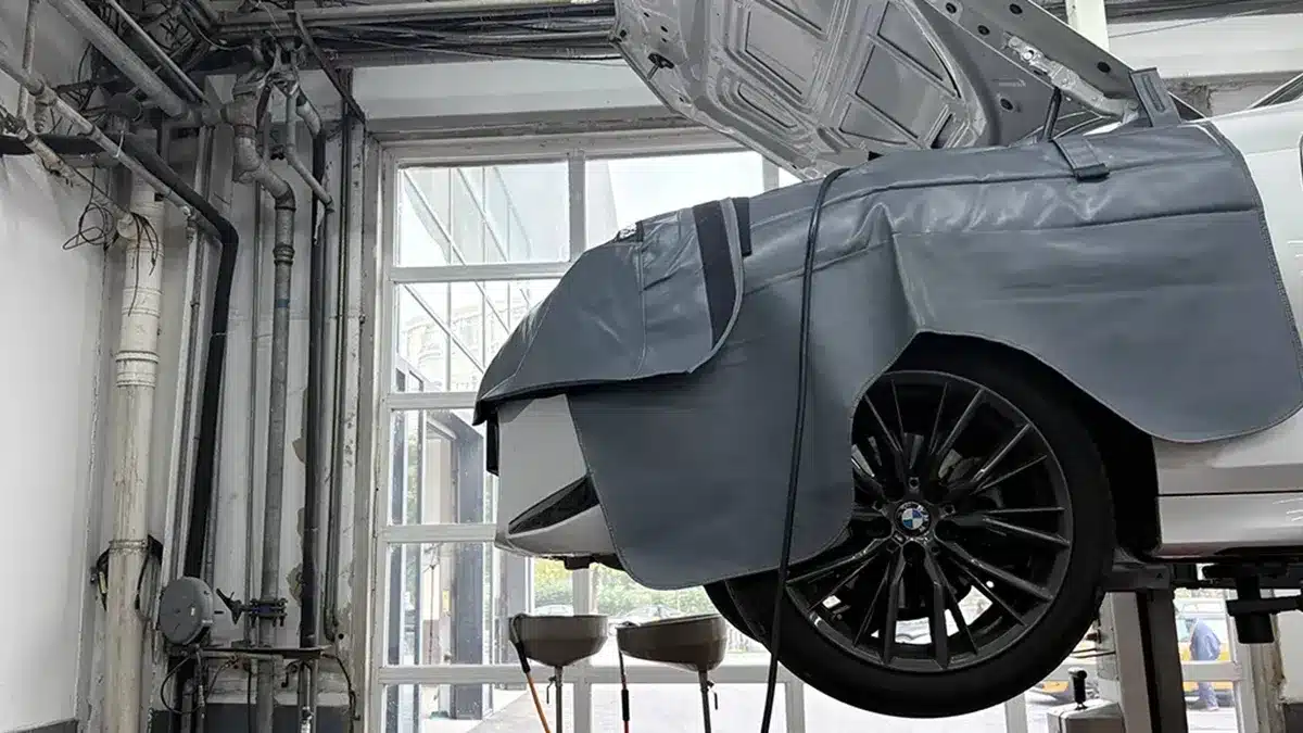 Cable ties in a BMW workshop service bay with a car on a lift