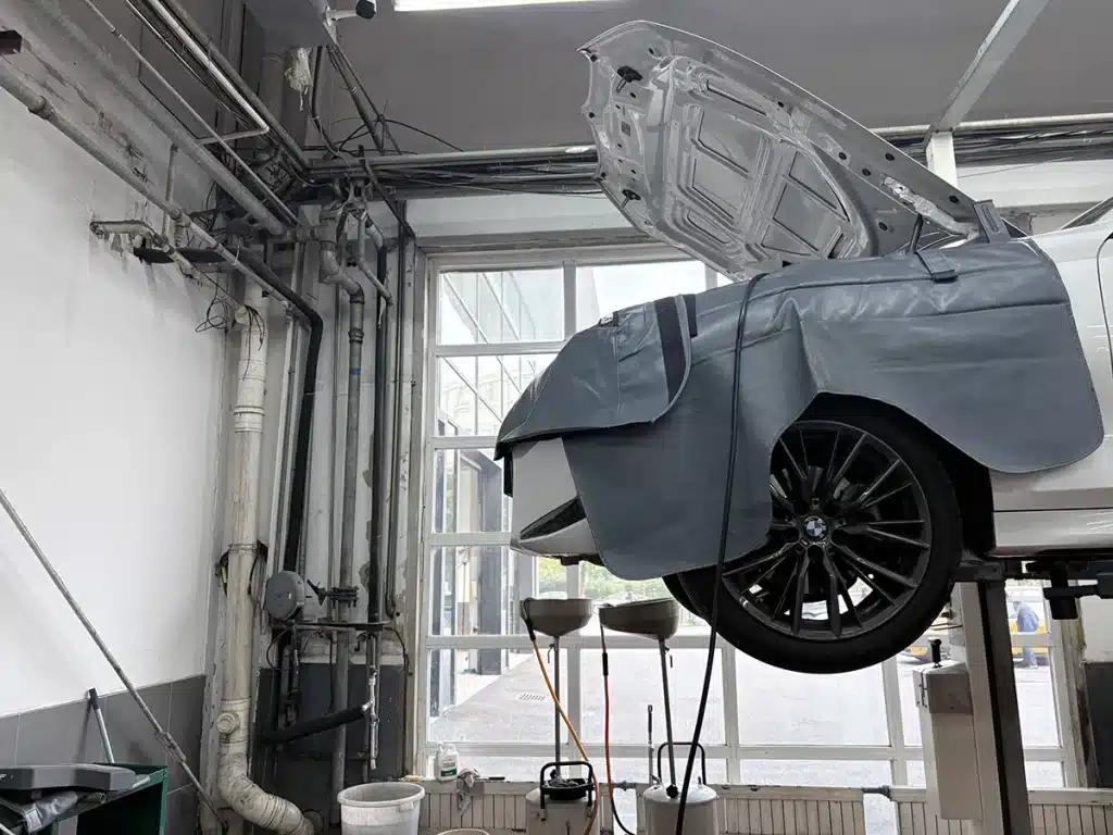 Cable ties in a BMW workshop service bay with a car on a lift