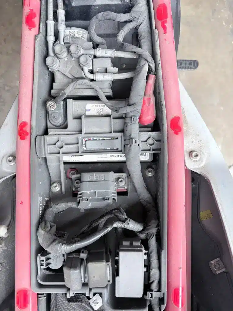 Cable ties organizing wiring harness inside the under-seat electrical compartment of a BMW motorcycle