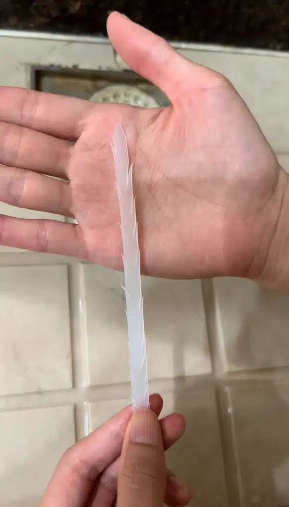 Cable tie modified with barbs for unclogging a sink drain by pulling out hair and debris