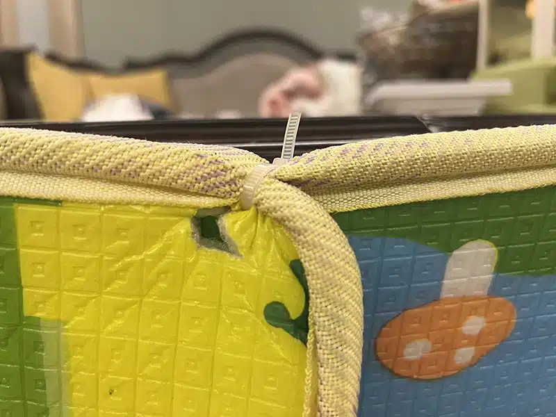 Cable tie securing anti-collision padding on a furniture edge to keep the protector from slipping