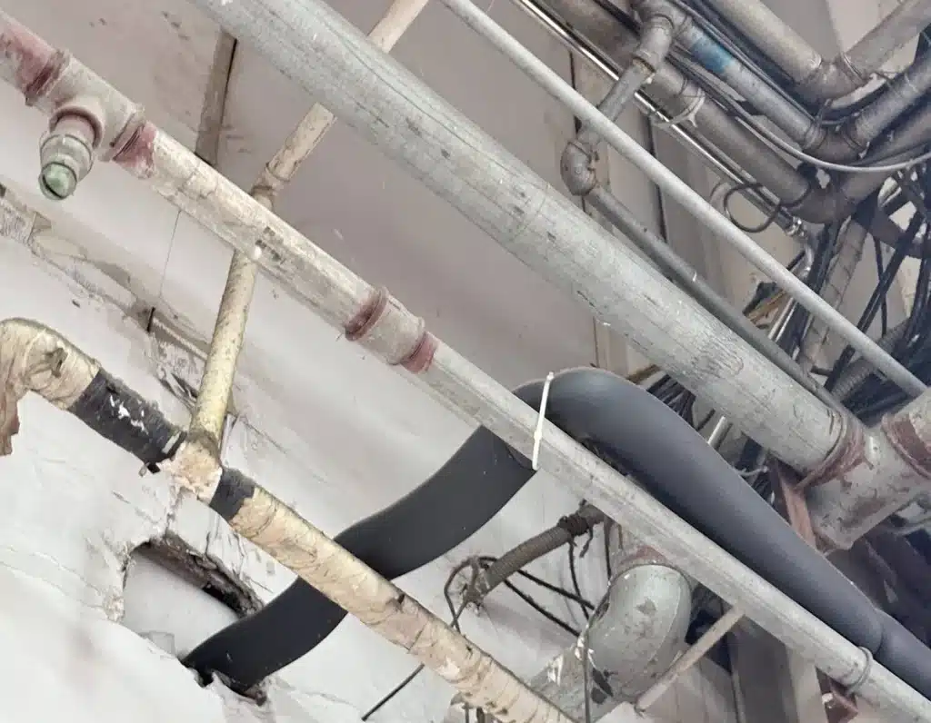 Cable ties used for hose and cable routing along ceiling pipework in a BMW service workshop