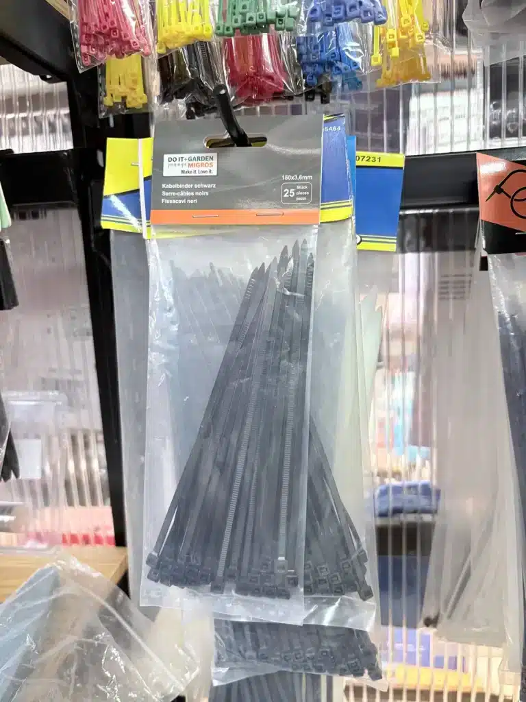 Black nylon cable ties in transparent retail bag packaging on a store shelf