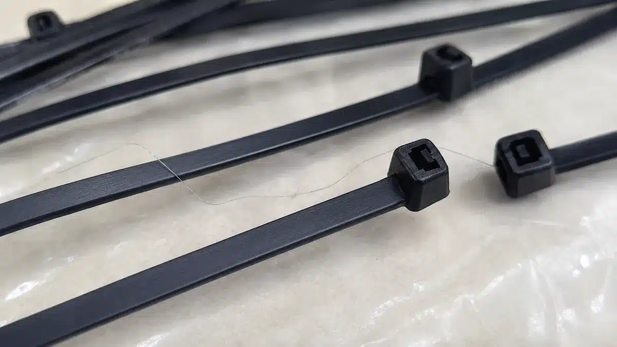 Hair-like nylon strand on black cable ties caused by injection molding stringing